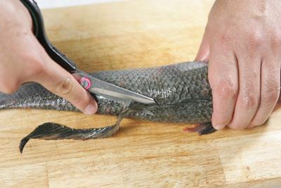 Dùng kéo cắt bỏ sạch phần vây ở lưng, bụng, hai bên ức và đuôi cá.