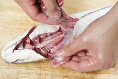 Để kéo ở ức cá, cắt đến phần rốn cá rồi kéo ruột ra, rửa sạch cá dưới vòi nước.
