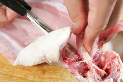 Dùng kéo cắt xương sống từ đuôi cá đến gần đầu cá.