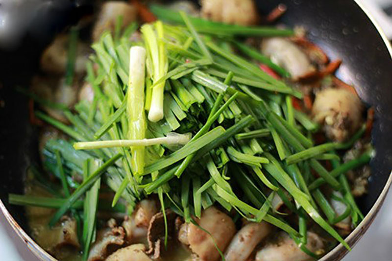 Nêm nếm gia vị, khi lòng chín thì cho hành tây, hẹ, rau răm và ớt vào đảo đều rồi tắt bếp.